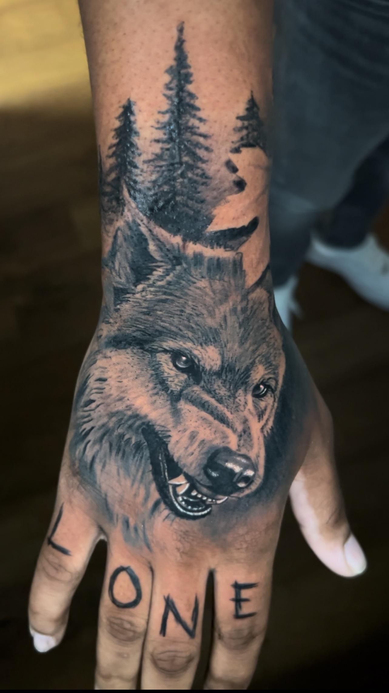 realistic wolf hand tattoo